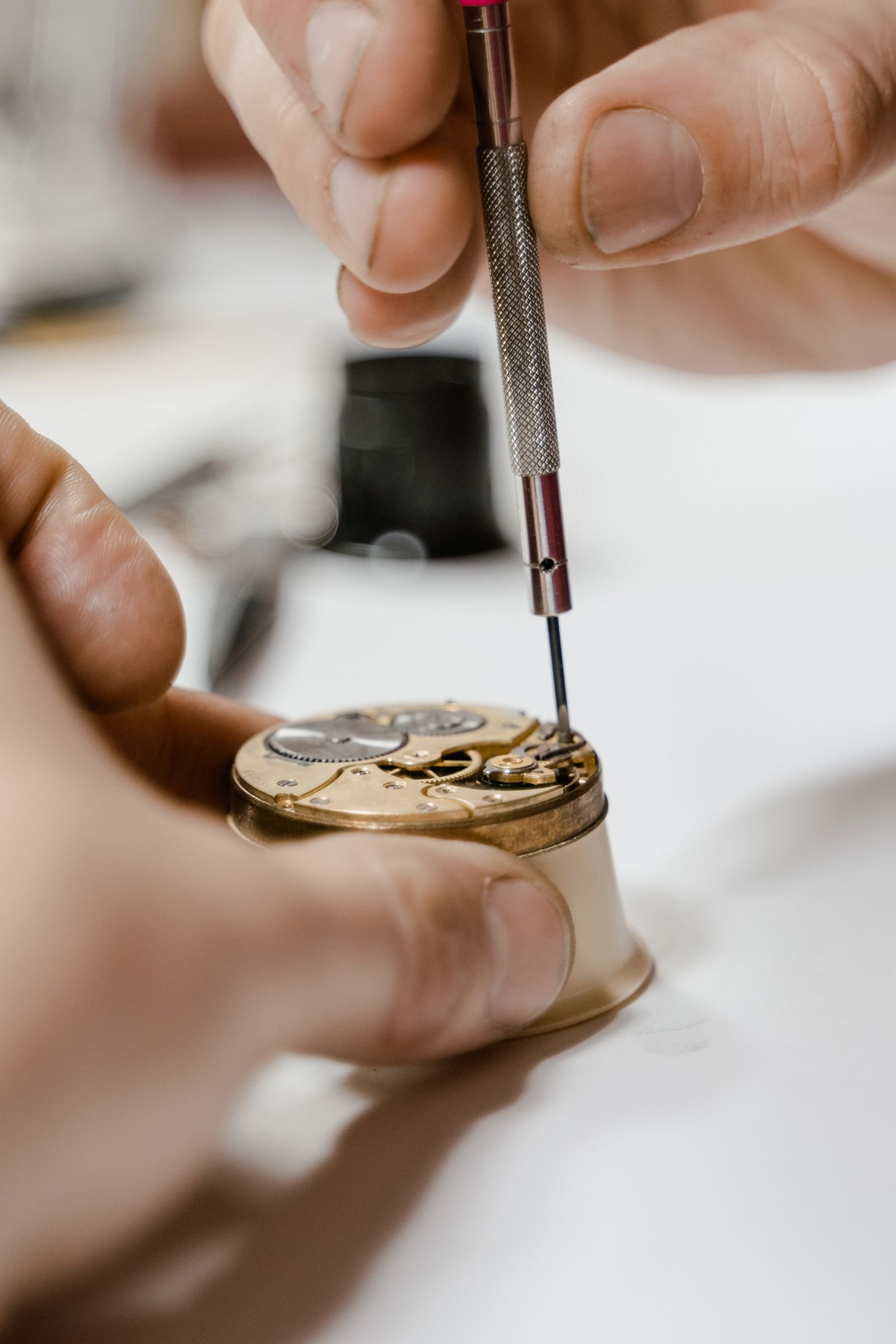 Watchmaker adjusting a wristwatch with tools in a workshop