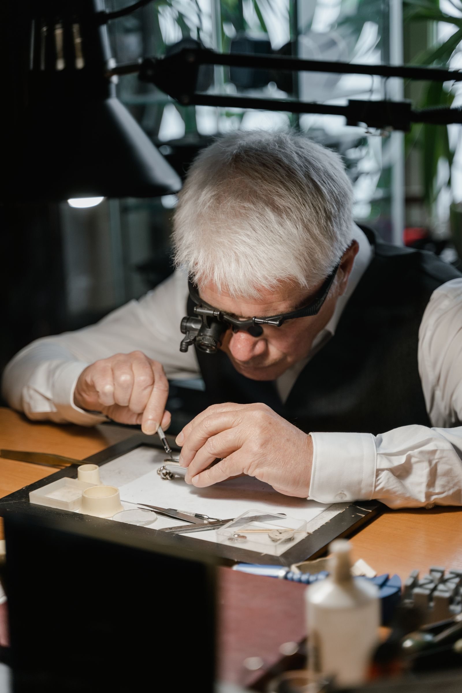 Watchmaker working on a watch mechanism at a repair bench