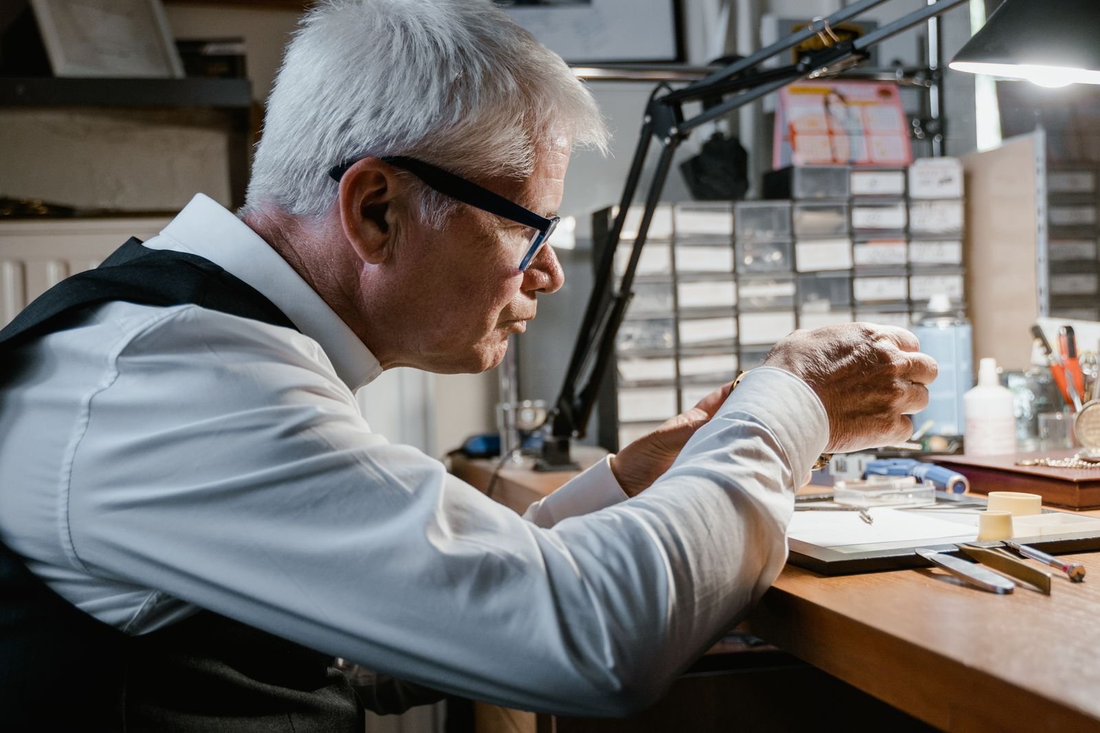 Watchmaker holding a watch mechanism during inspection