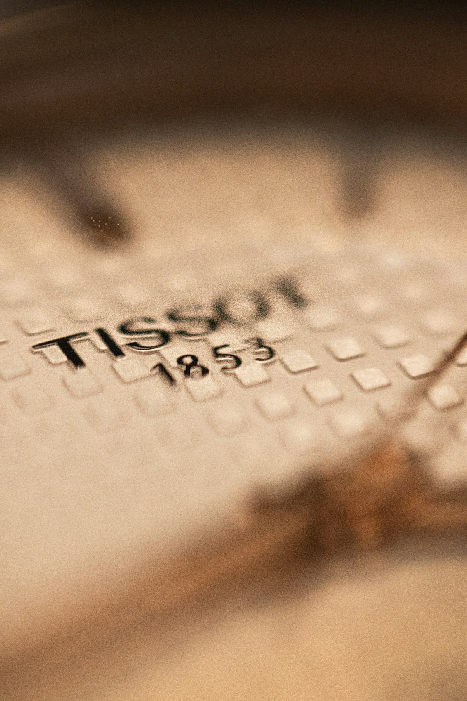 Macro close-up of a wristwatch dial and hands under soft light