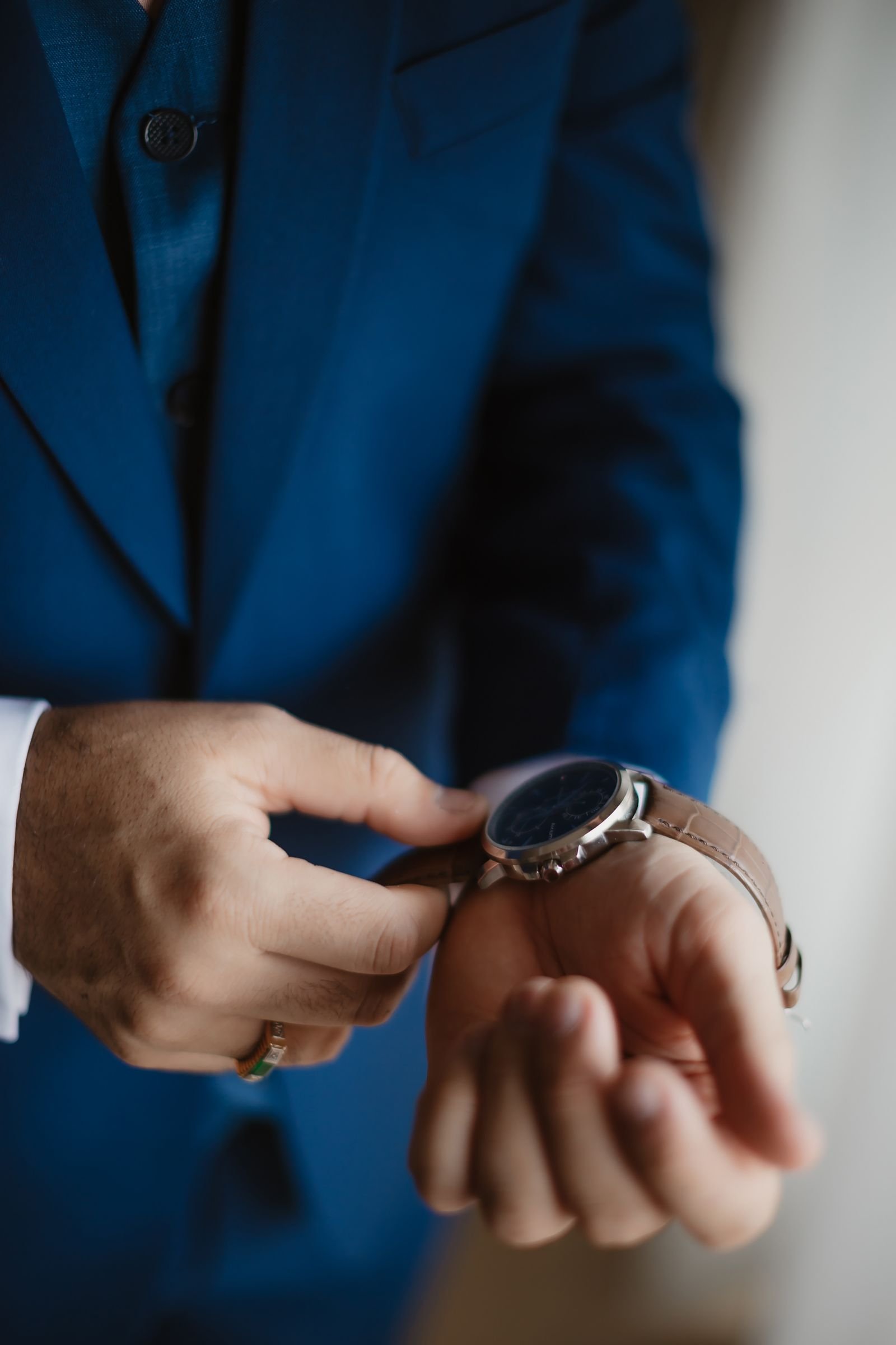 Close-up of a person adjusting a wristwatch with fingers on the crown