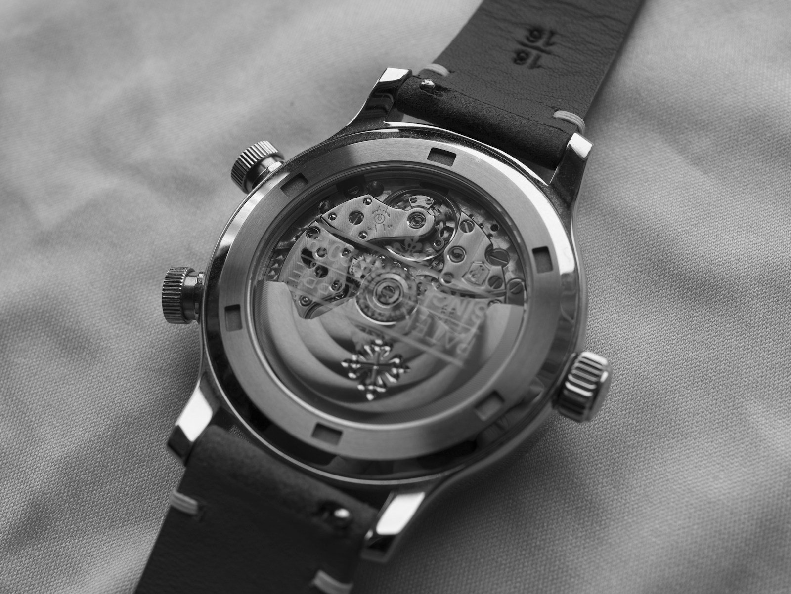 Grayscale close-up of a round chronograph wristwatch with multiple subdials
