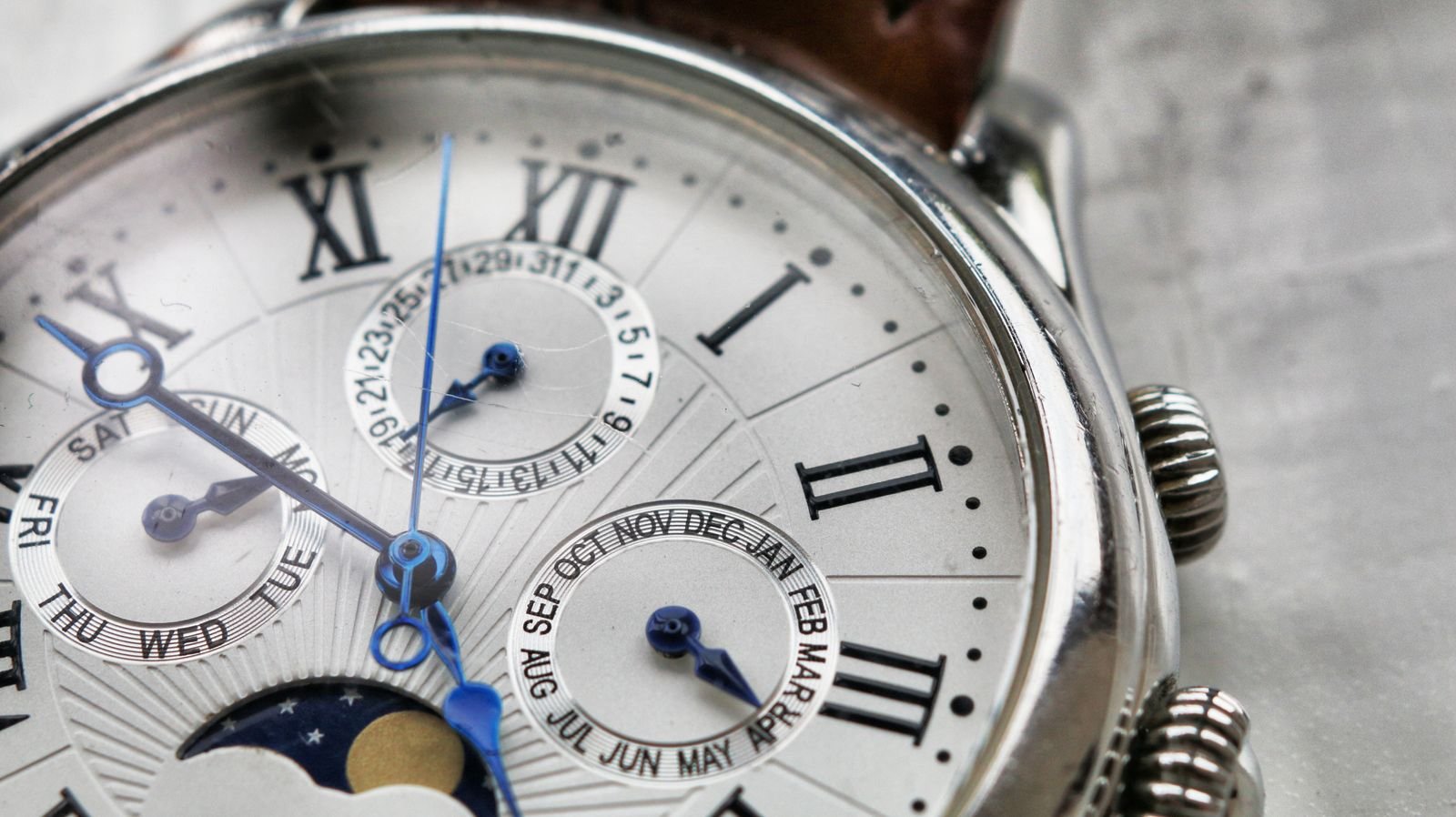 Macro view of a wristwatch dial beneath a clear crystal