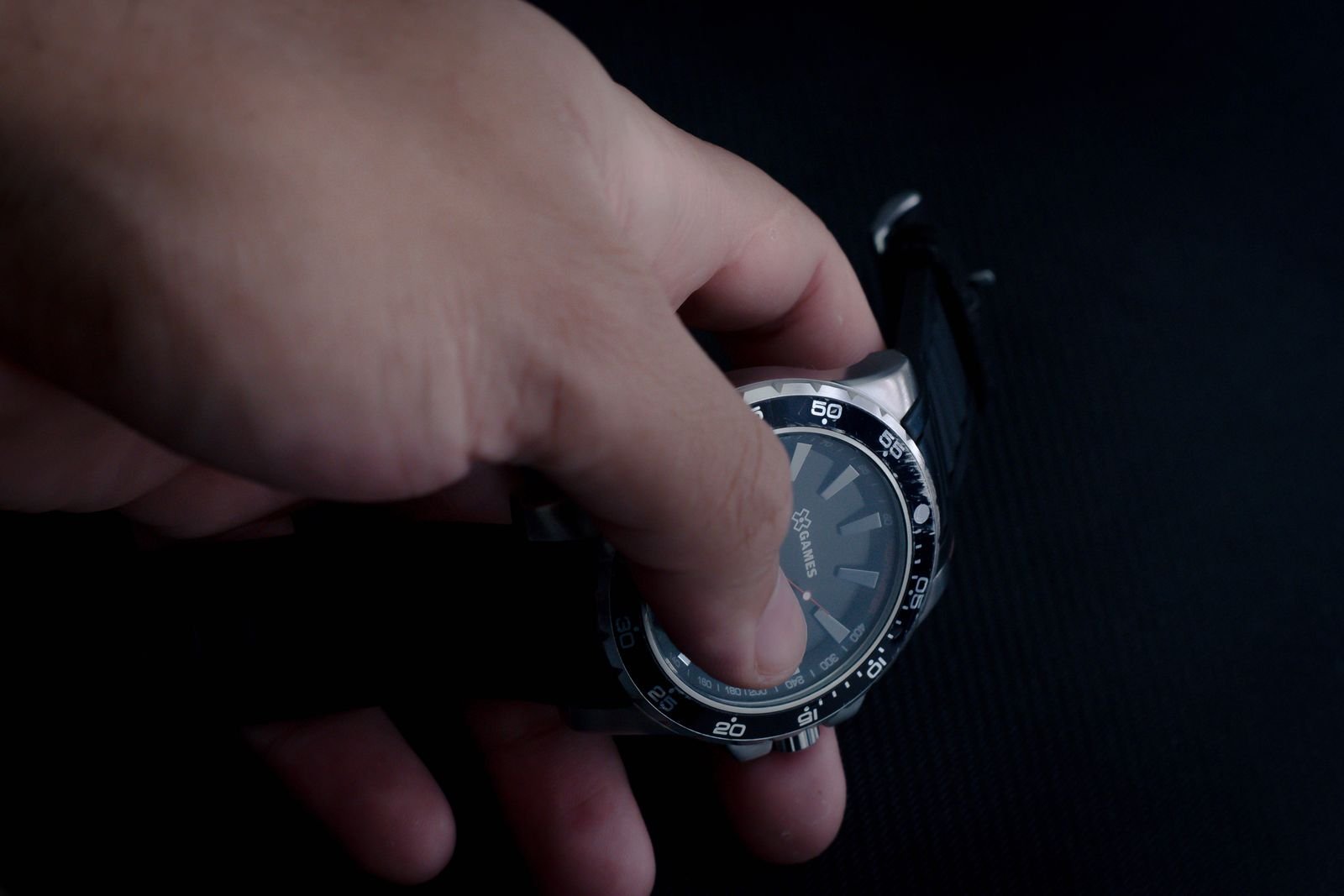 Person holding a wristwatch to inspect its crystal and dial