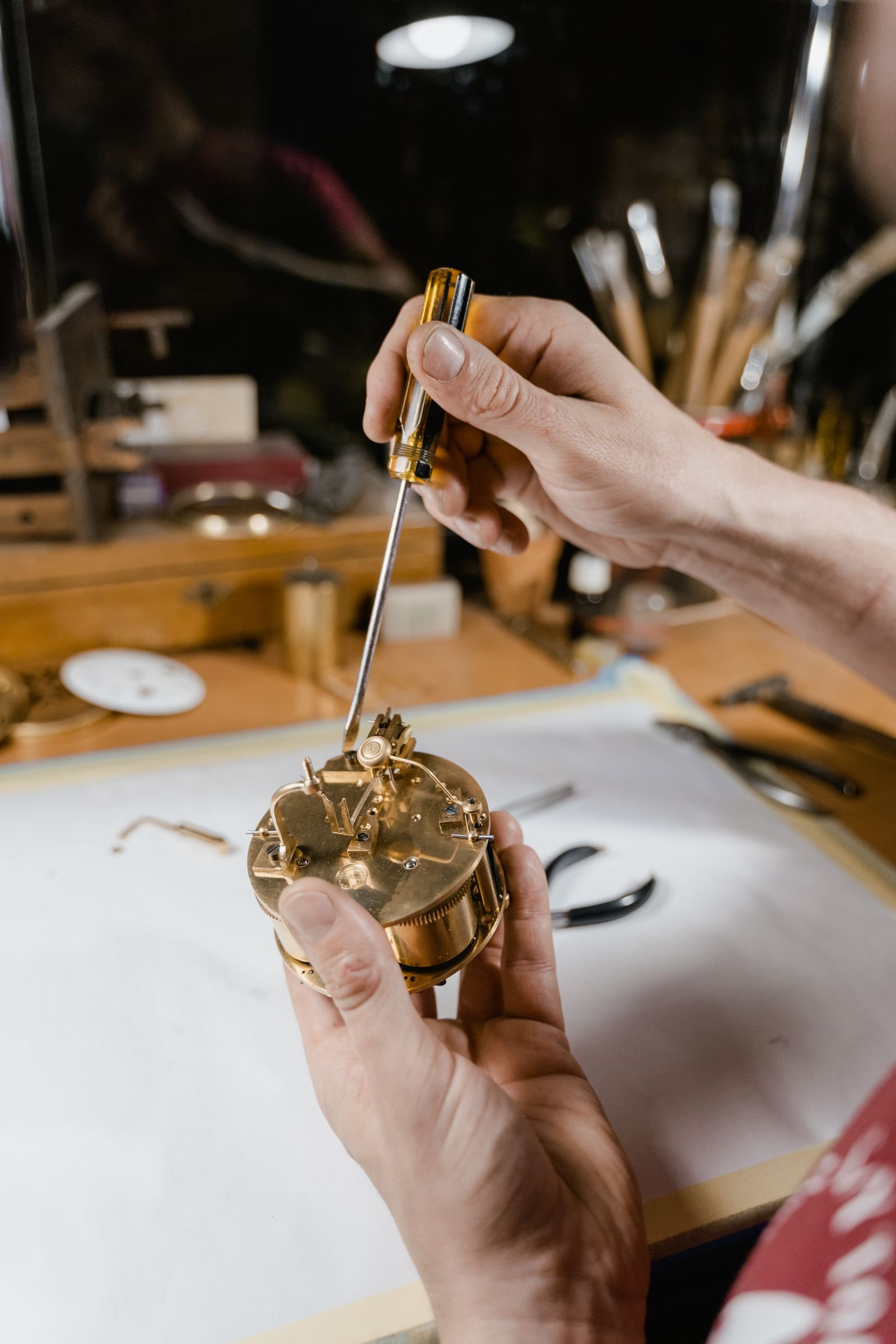 Watchmaker using precision tools to diagnose an automatic watch that keeps stopping