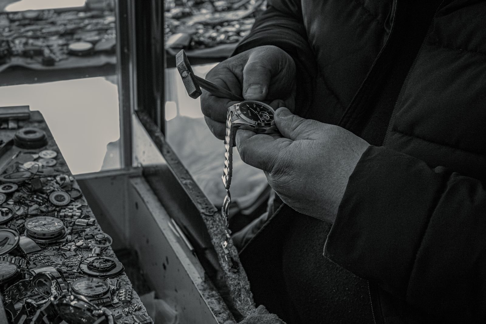 Watchmaker using precision tools to inspect an automatic watch movement