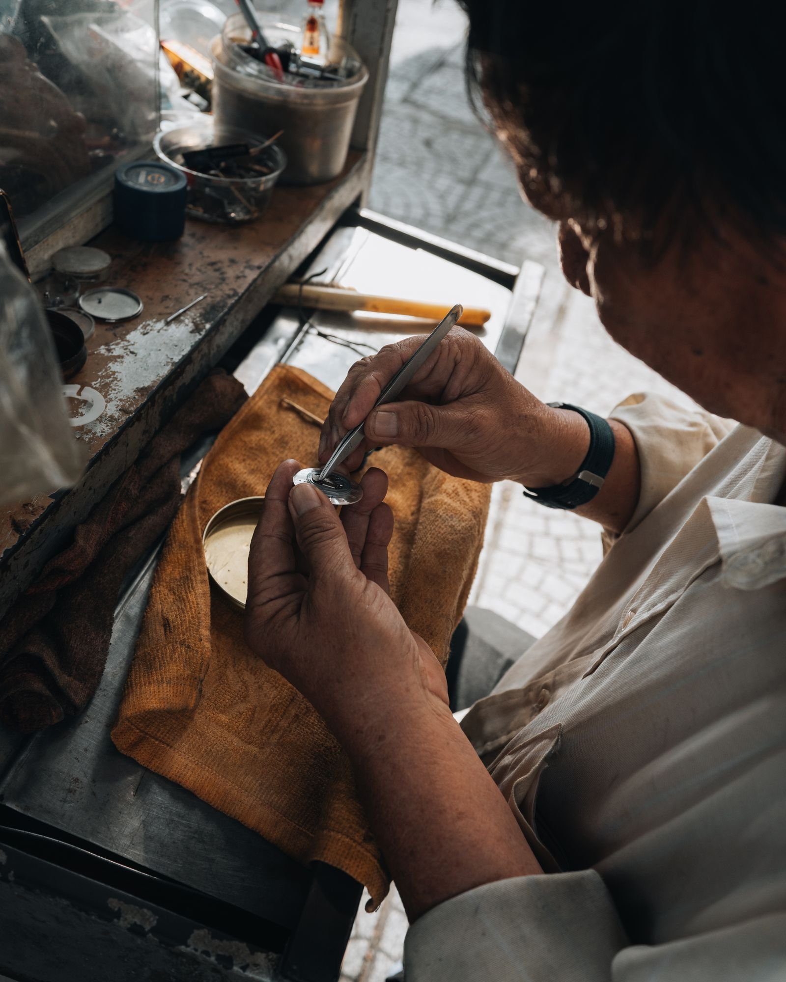 Watchmaker inspecting case and dial details during luxury watch authentication