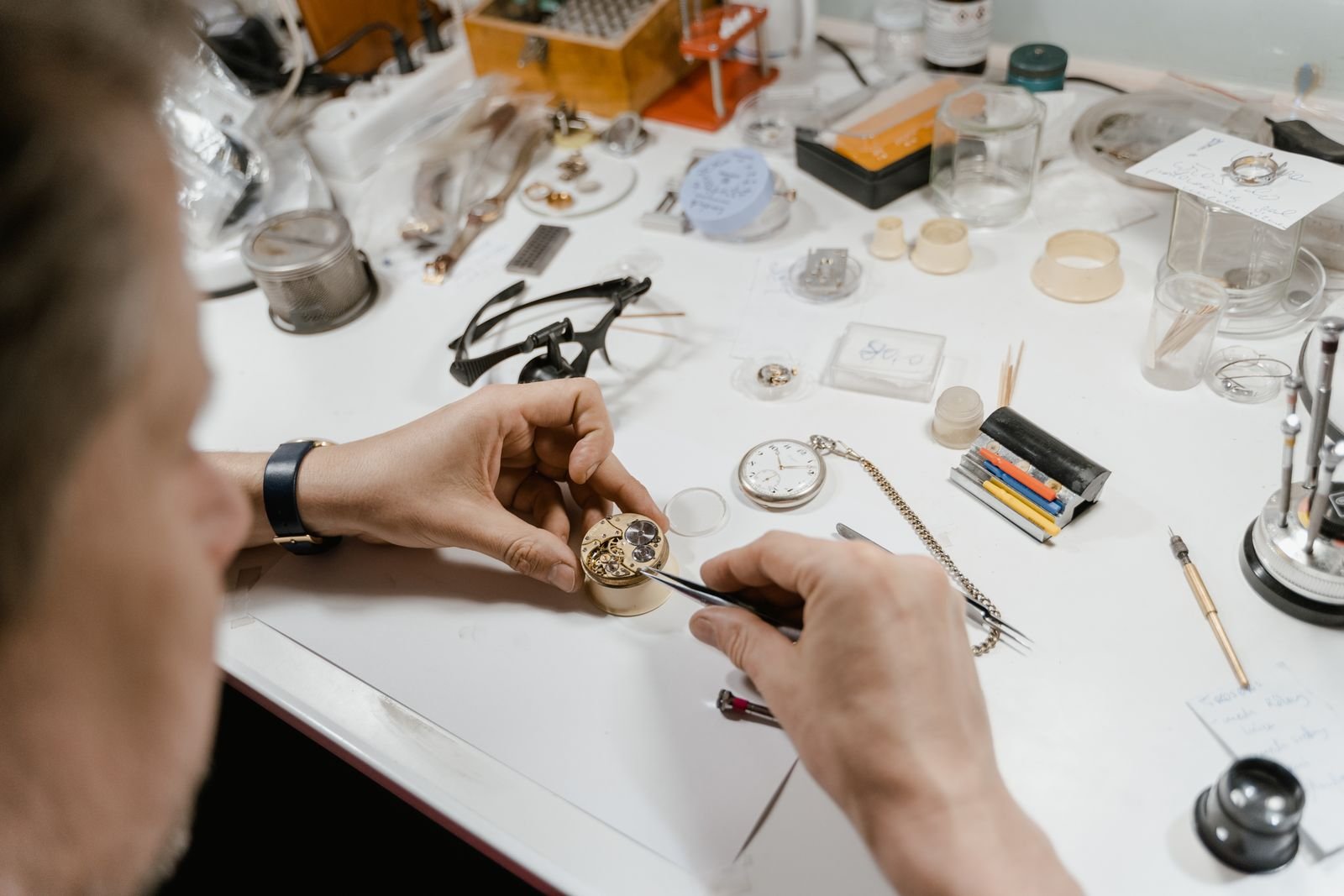 Watchmaker inspecting the movement and barrel during mainspring diagnosis
