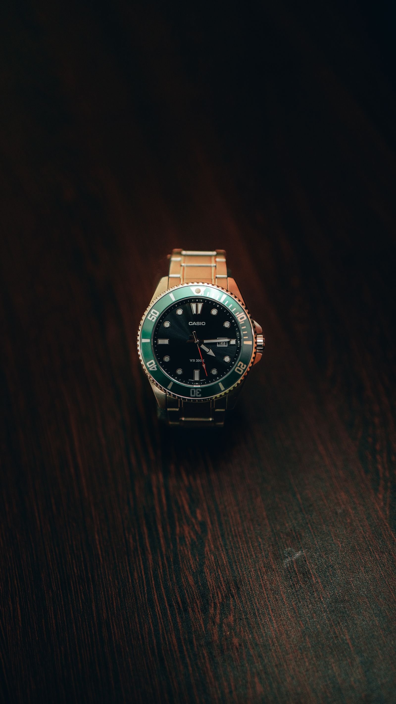 Mechanical wristwatch resting overnight on a dark wooden table