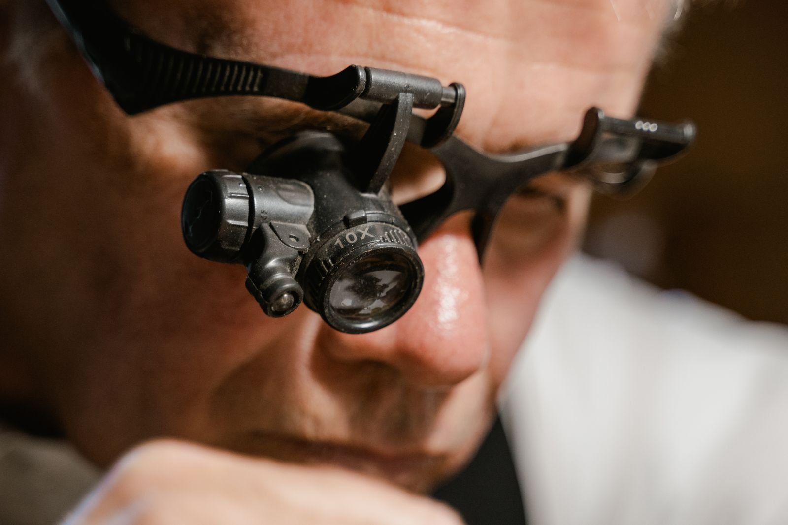 Watch specialist using a magnifier to inspect fine mechanical details