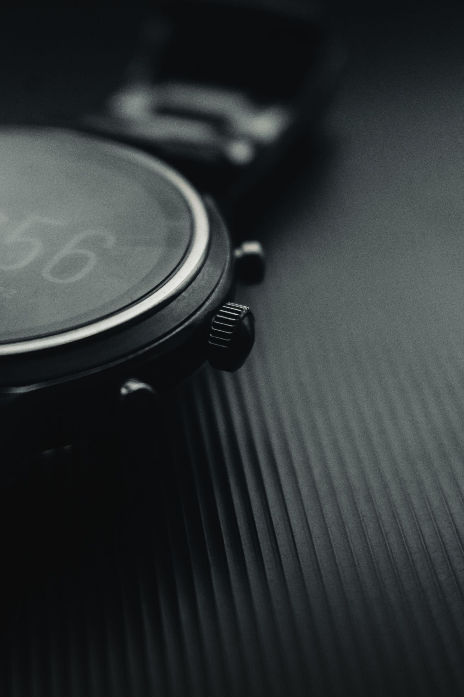 Black wristwatch with reflective crystal examined for coating damage