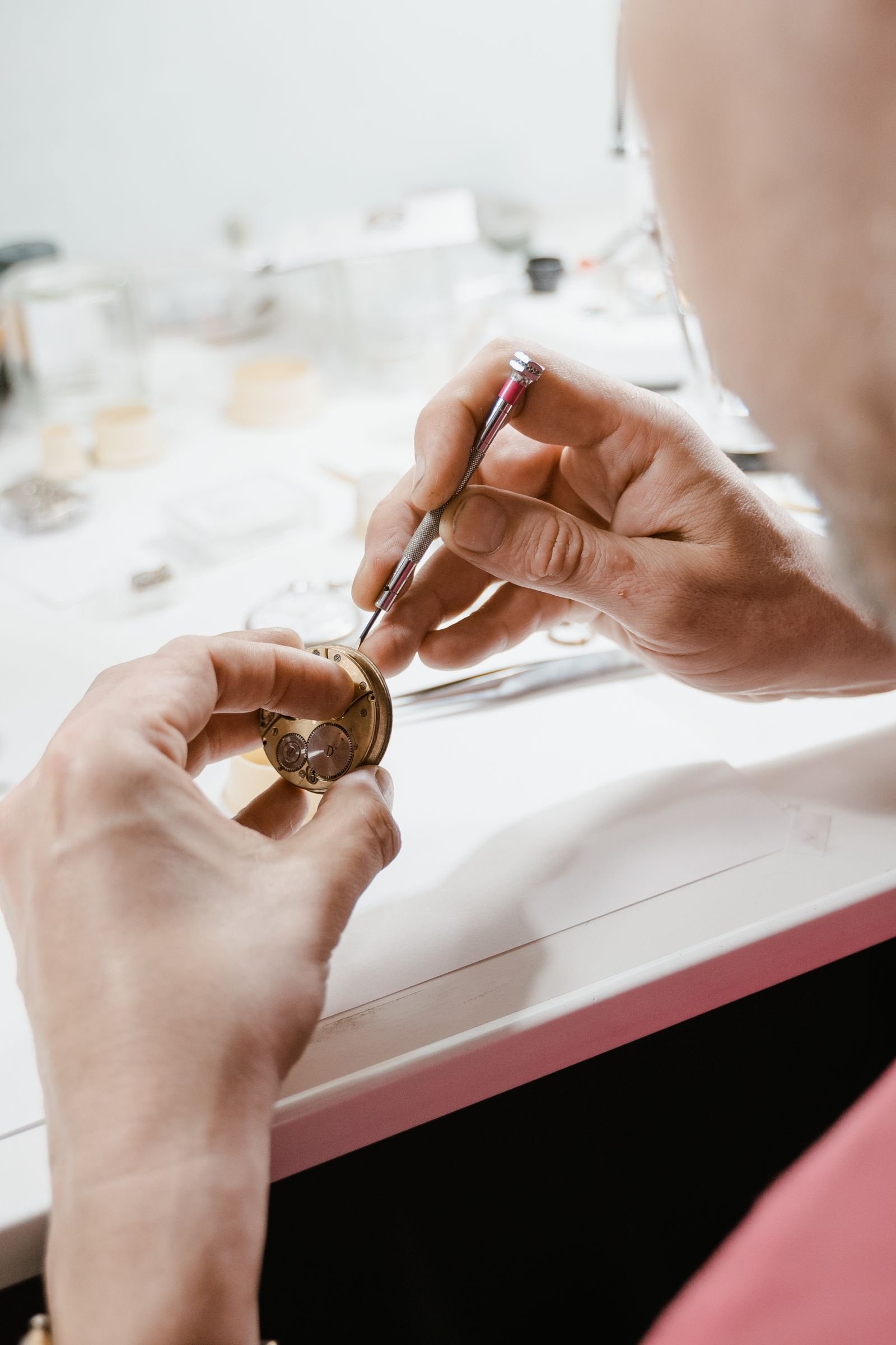Watchmaker repairing the winding mechanism of a mechanical watch with precision tools