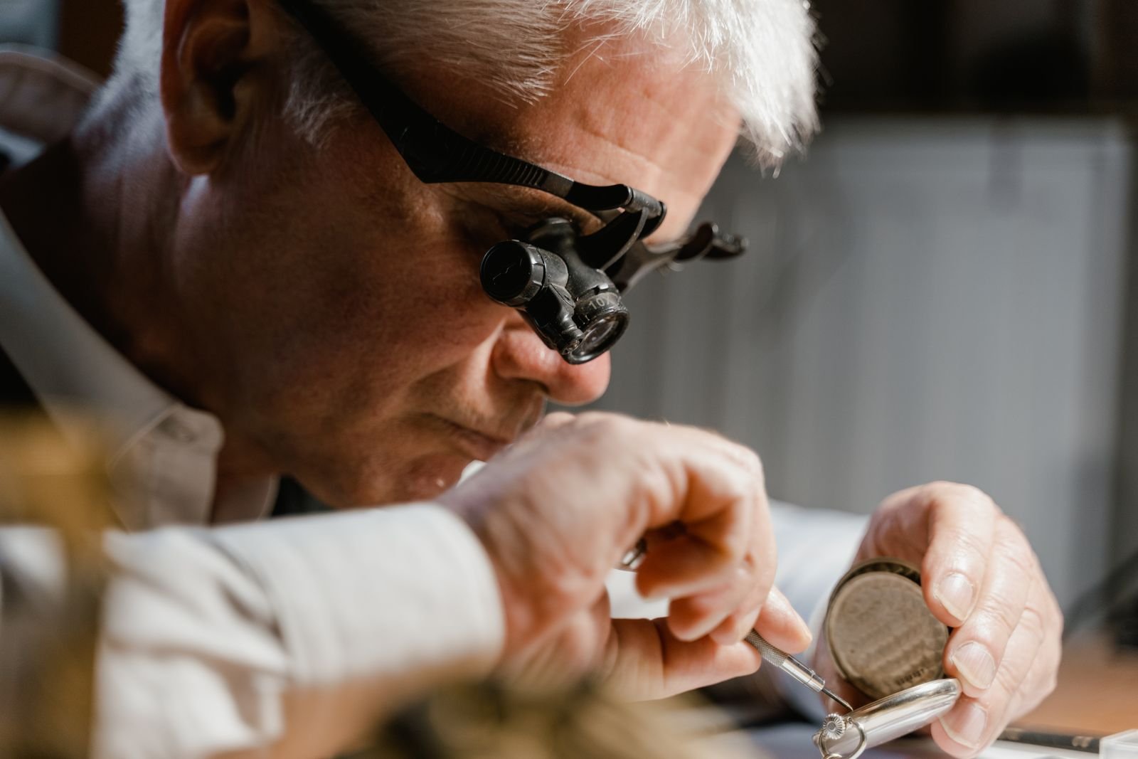 Watchmaker inspecting a serviced mechanical watch for timing accuracy