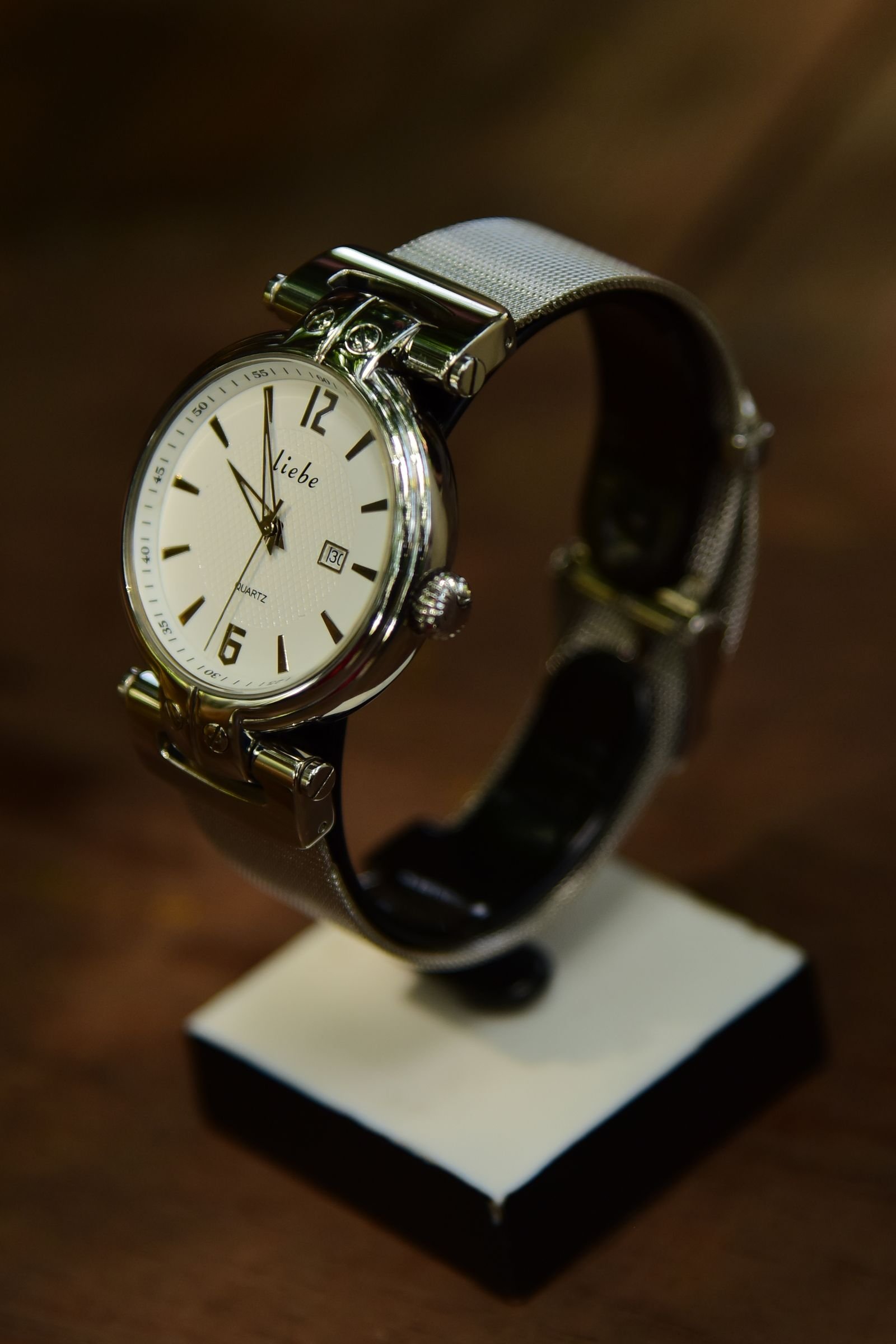 Small silver wristwatch displayed upright for a winder fit and position check