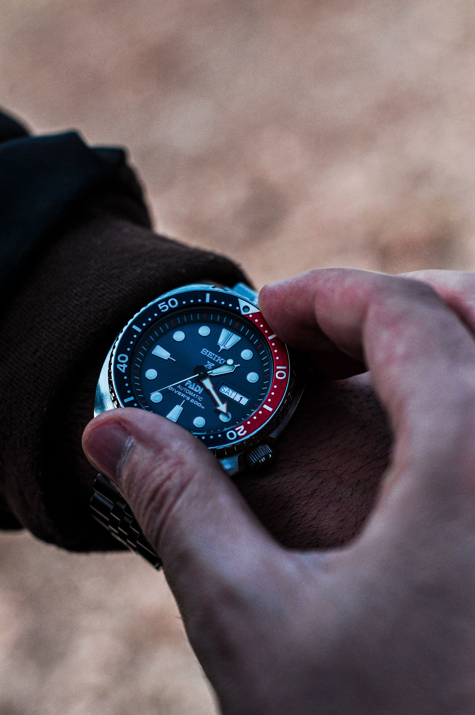 Close-up dive watch used to compare bezel dial hands and date details