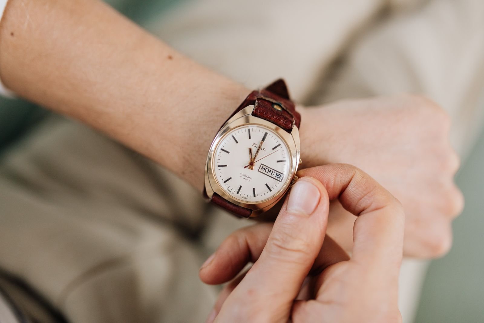 Owner gently turning the crown while checking whether an automatic watch rotor spins when winding