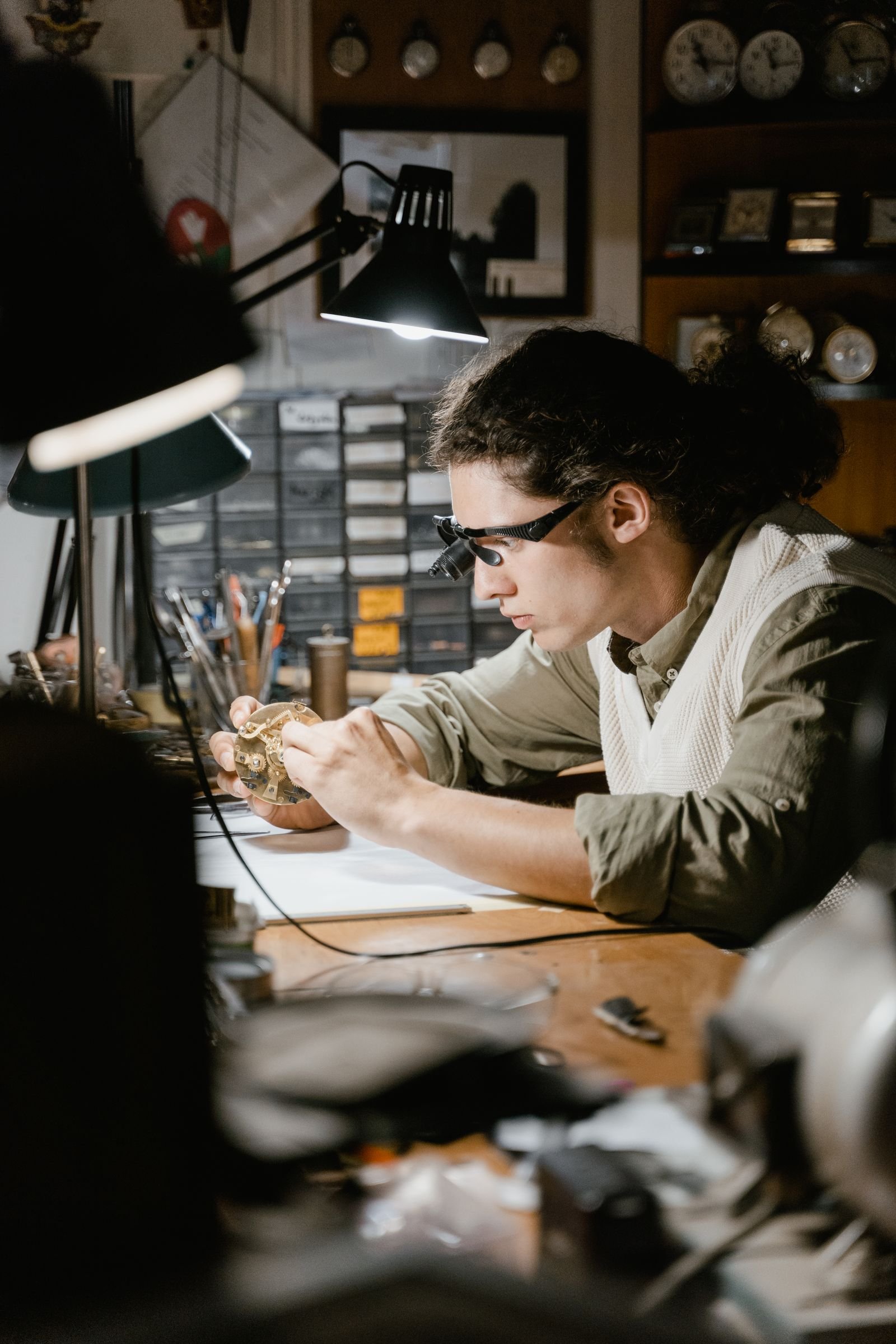Watchmaker using magnification to inspect dial and movement details during Rolex Explorer authentication