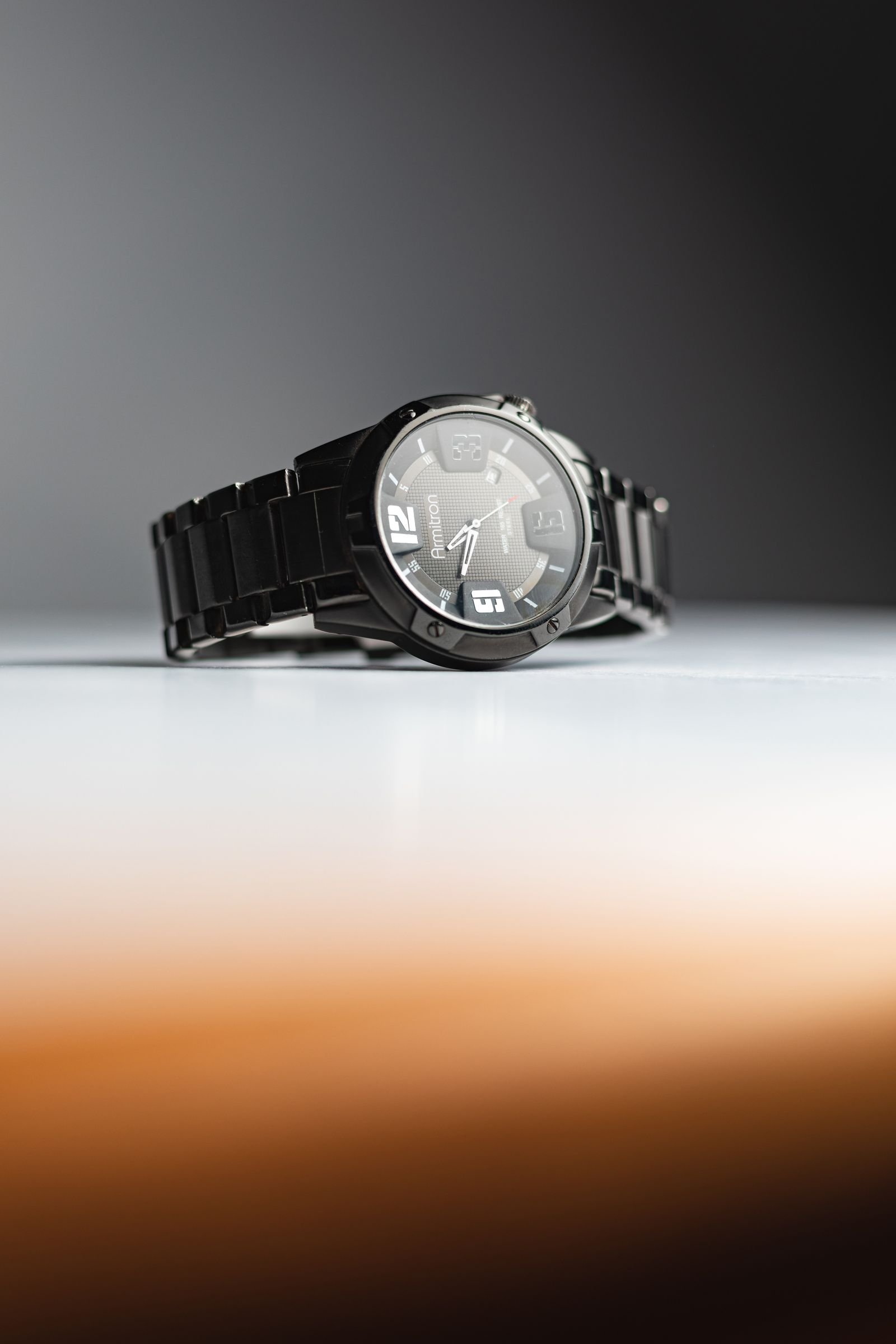Black wristwatch photographed closely to document case dial and bracelet details before purchase