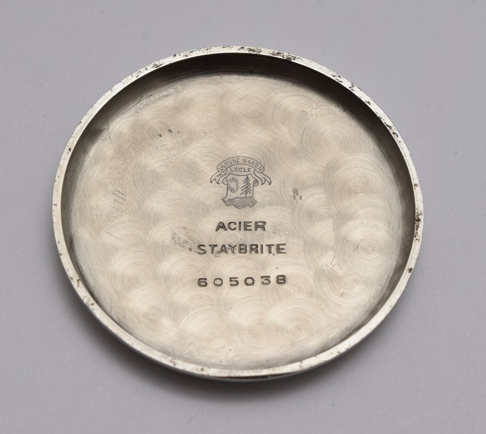 Engraved mechanical watch caseback used to illustrate serial and case marking inspection