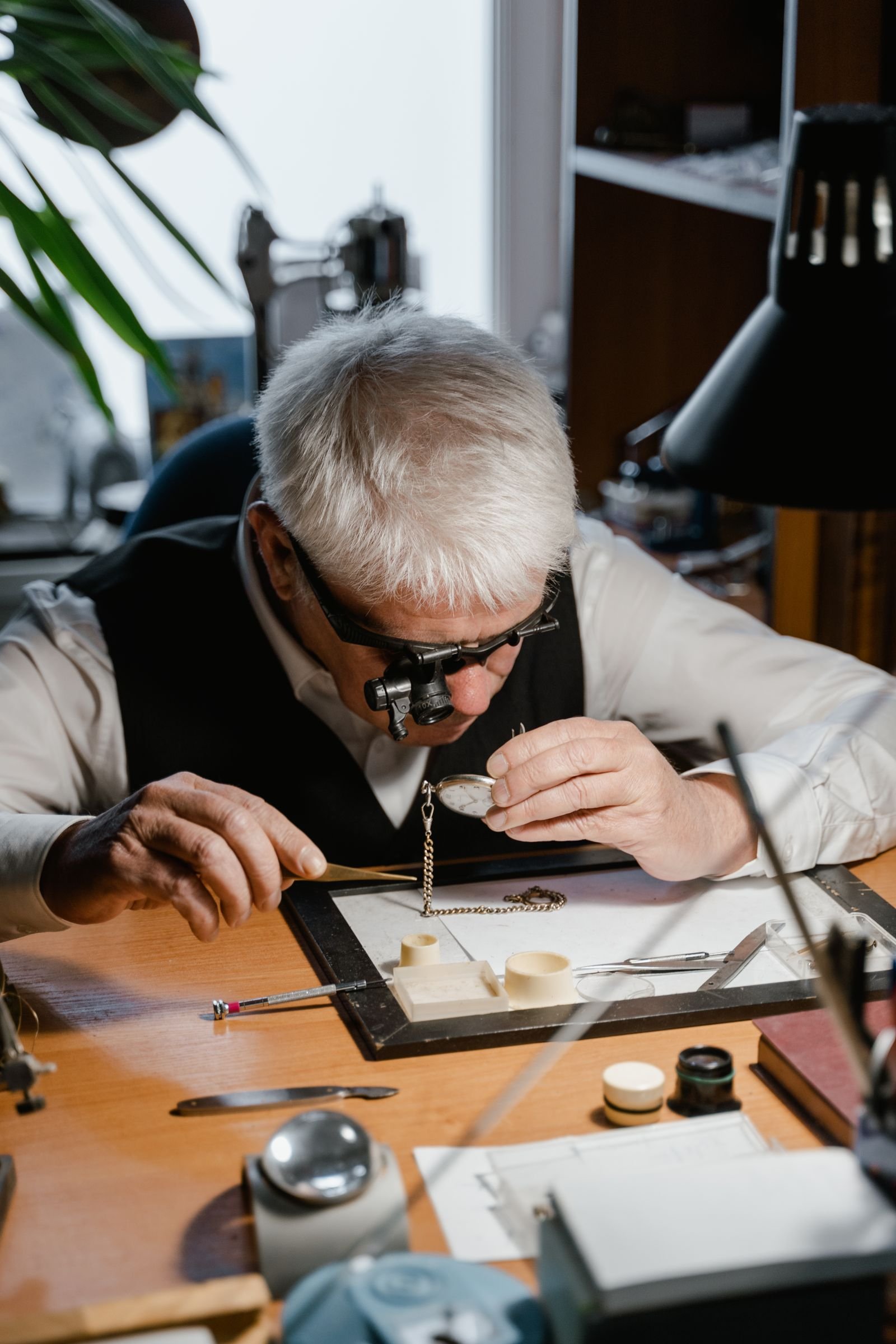 Experienced watchmaker working on a mechanical timepiece at a repair bench