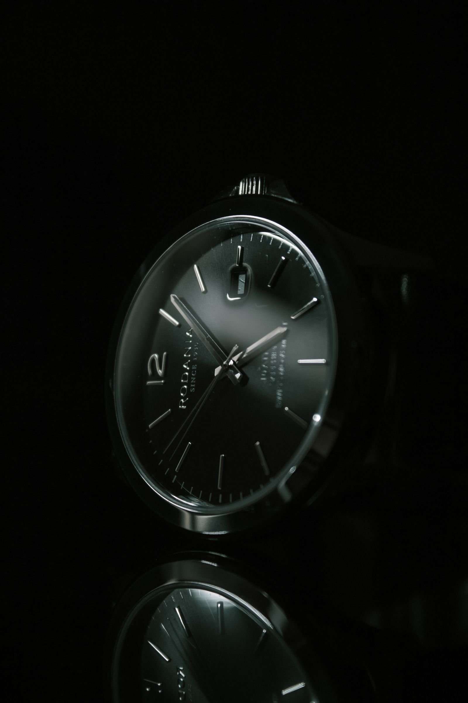 Close-up black analog watch used to compare minute hand position before and after pressing the crown