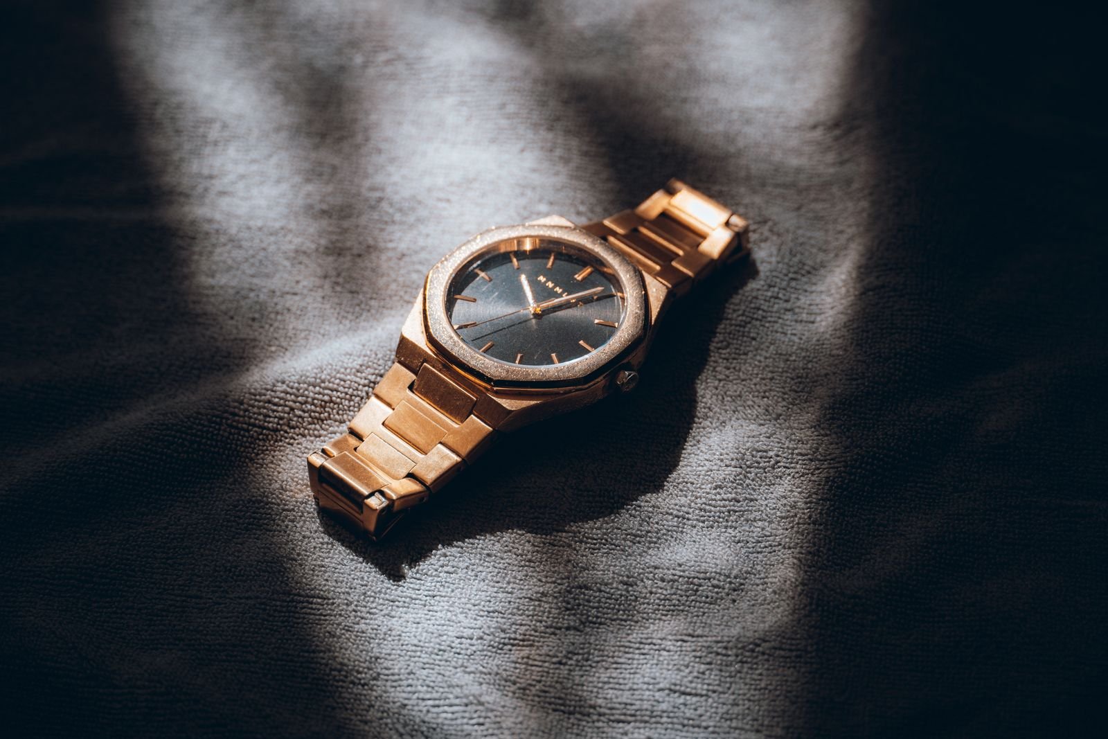 Polished metal watch photographed closely to compare dial case and crown finishing