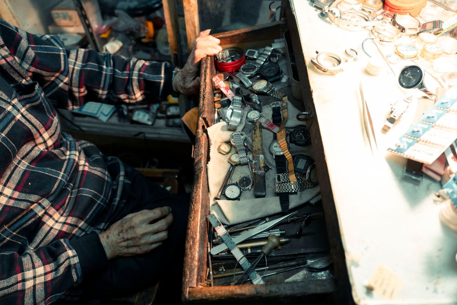 Watchmaker selecting watches and tools for mechanical inspection
