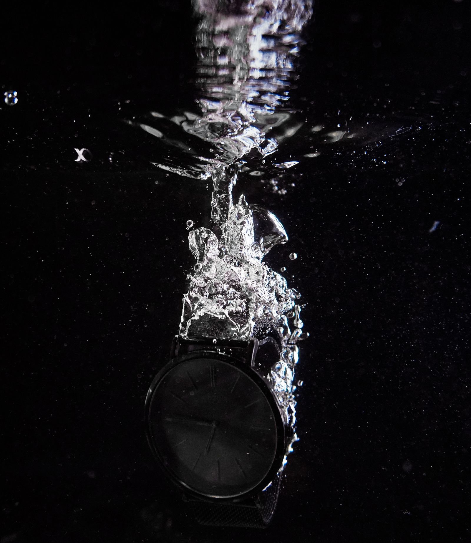 Water splashing around a wristwatch while explaining watch crystal fogging