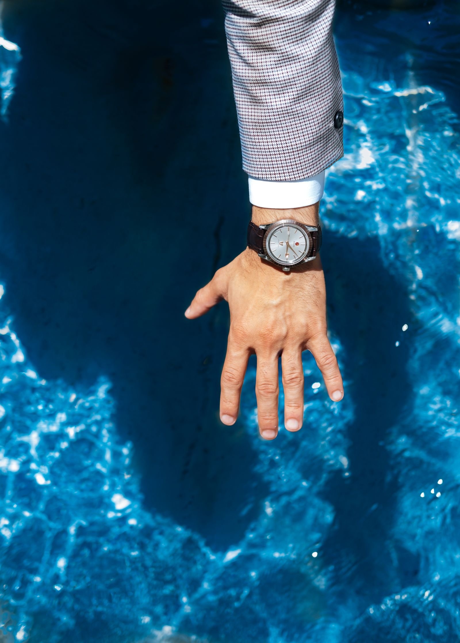 Wristwatch worn beside water before checking its crown and water resistance